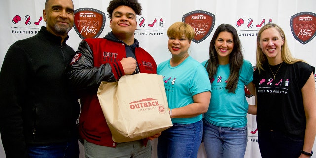 From left to right, Jon Seaton Sr., Elon University football player Jon Seaton, breast cancer survivor Carole Seaton, Fighting Pretty founder Kara Frazier and Fighting Pretty director of outreach Corrine Christian at the Feb. 2, 2023, event in Elon, North Carolina. Football player Seaton called it "one of the proudest moments of my life so far."