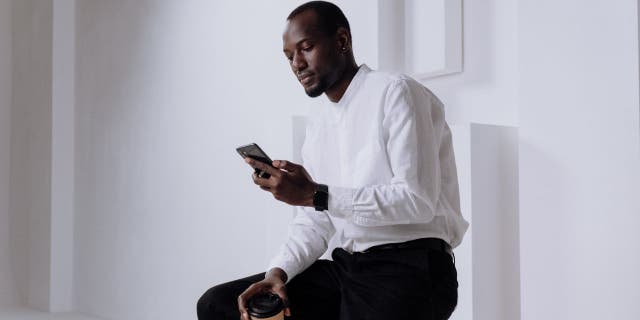 Image of a man using his iPhone. 