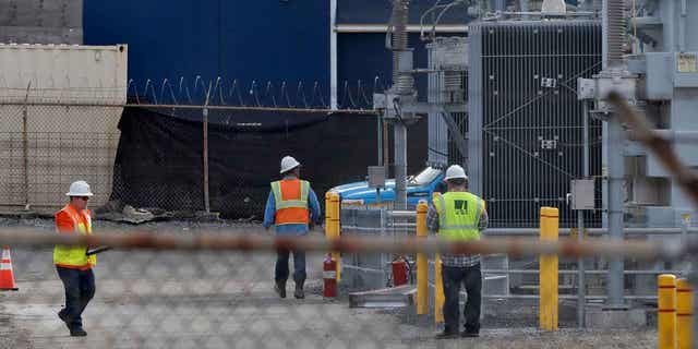 PG&E workers at a substation where a fire earlier in the day caused power outages in parts of Oakland, California on Sunday, Feb. 19, 2023. 