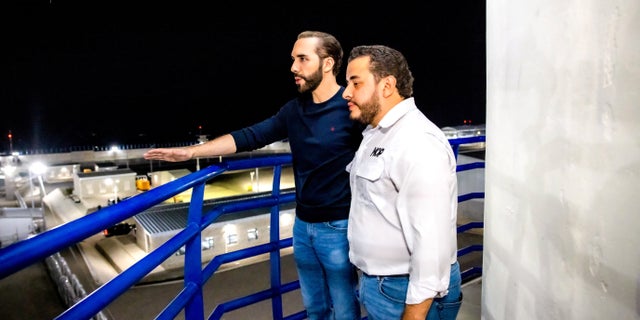 President Nayib Bukele stands in an observation tower with the Minister of Public Works Romeo Rodriguez during a national television transmission to present the Terrorism Confinement Center on Feb. 1, 2023.