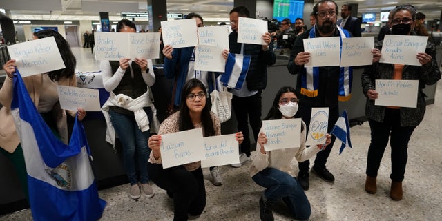 Activists hold up signs with the names of some of the more than 200 political prisoners released from Nicaragua, as they await their arrival at Dulles International Airport in Virginia outside Washington, D.C., February 9, 2023. 