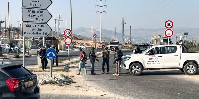 Israeli security personnel stand as they guard a main junction, close to where Israeli police said two Israelis were killed, near Nablus, in the Israeli-Occupied West Bank, February 26, 2023. 