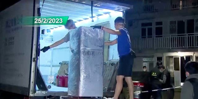 La policía carga un refrigerador que se sospecha que se usó para guardar partes del cuerpo de la modelo Abby Choi, de 28 años, en un camión en Hong Kong el 25 de febrero de 2023 en esta captura de pantalla tomada de un video.