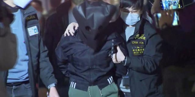 Police officers escort a 47-year-old suspect in connection with the killing of 28-year-old model Abby Choi, in Hong Kong Feb. 26, 2023 in this screenshot taken from a video.