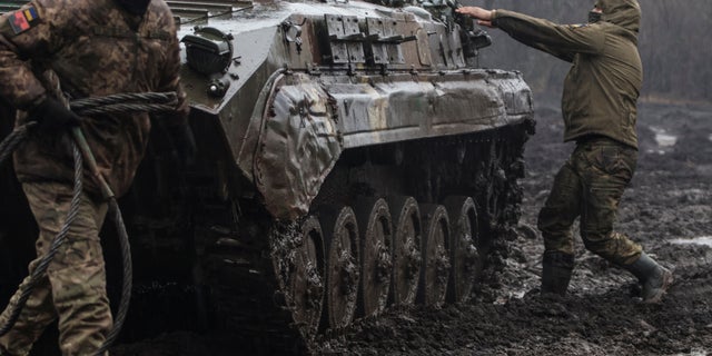 El personal de servicio ucraniano se ve junto a un vehículo de combate de infantería cerca de la ciudad de Pakhmut en la línea del frente, en medio de un ataque ruso contra Ucrania, en la región de Donetsk, Ucrania, el 25 de febrero de 2023. 