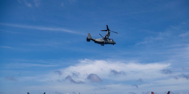 An Osprey flies past the flight deck of the USS Nimitz as it conducts exercises in the South China Sea on Feb. 11.