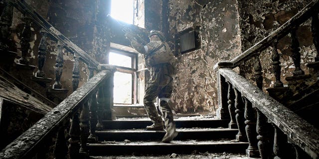 A Russian soldier climbs stairs at the Mariupol drama theatre, hit on March 16 by an airstrike, on April 12, 2022, in Mariupol, as Russian troops intensify a campaign to take the strategic port city, part of an anticipated massive onslaught across eastern Ukraine, while Russia's President makes a defiant case for the war on Russia's neighbor. 