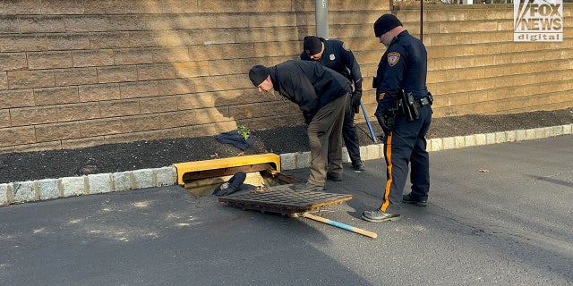Police searching sewage point at the Sayreville apartment complex where Eunice Dwumfour was killed on Feb. 1, 2023. The blue piece of fabric that was pulled from the grate is shown.