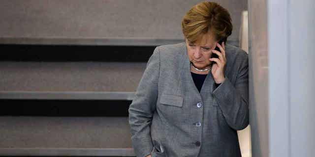 German Chancellor Angela Merkel speaks on the phone during a break at a meeting in Berlin, Germany.  Russian pranksters posed as Petro Poroshenko to contact Angela Merkel by phone and discuss Ukraine.