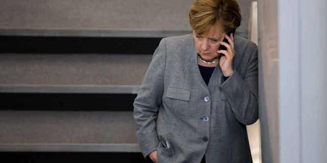 German Chancellor Angela Merkel speaks on the phone during a meeting break in Berlin, Germany. Russian pranksters posed as Petro Poroshenko to reach Angela Merkel by phone to discuss Ukraine.