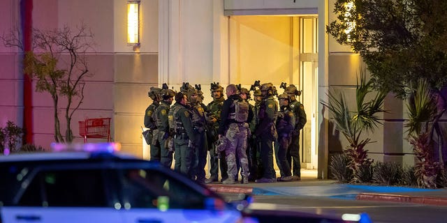 Police officers gather at an entrance of a shopping mall on Feb. 15, 2023, in El Paso, Texas. One person was killed and three other people were injured in a shooting at Cielo Vista Mall.