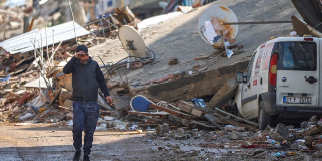 A man walks past debris from destroyed buildings in Antakya, southeastern Turkey, on Feb. 21, 2023.
