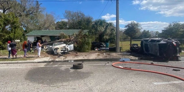 Photos show the massive wreck with damage to the house, a tire and other debris in the road, and a palm tree that fell on top of one of the crashed cars. 
