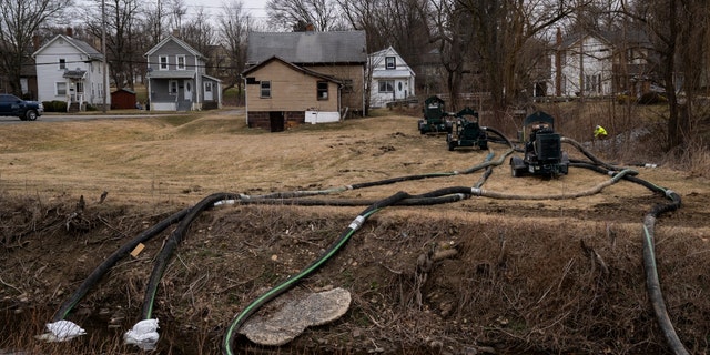 A clean-up crew works alongside a stream as clean-up efforts continue on Feb. 16, 2023, in East Palestine, Ohio. 