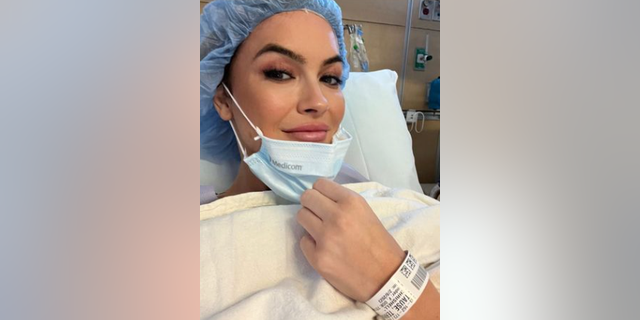 The 41-year-old reality television star shared a selfie to her Instagram story, wearing a medical mask and hairnet in a hospital bed. 