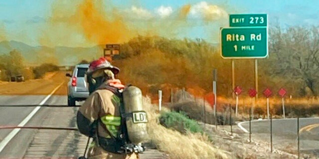 Personnel work to control the hazardous material leak and brush fire incidents at Rita Road and Interstate 10 near Tucson, Arizona, on Tuesday, Feb. 14, 2023.