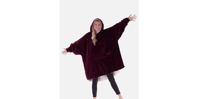 A woman is modeling the COMFY wearable blanket. 