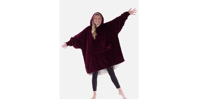 A woman is modeling the COMFY wearable blanket. 