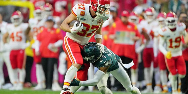 Kansas City Chiefs tight end Travis Kelce, #87, runs with the ball against Philadelphia Eagles cornerback James Bradberry, #24, during the first quarter of Super Bowl LVII at State Farm Stadium in Glendale, Arizona, Feb. 12, 2023.