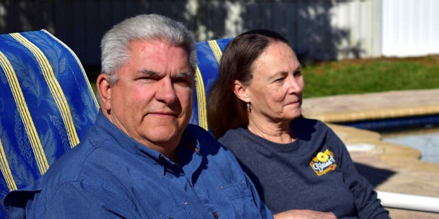 Louis Minardi and Raye Ellen Minardi sit by their pool on Gunn Highway in Odessa, Fla., on Jan. 29, 2023. The swimming pool in the backyard of Louis Minardi’s home may be distinctive to Florida: The custom-built pool is shaped like a six-shooter revolver, in a state made famous – sometimes infamous – by guns, gun politics and gun culture.