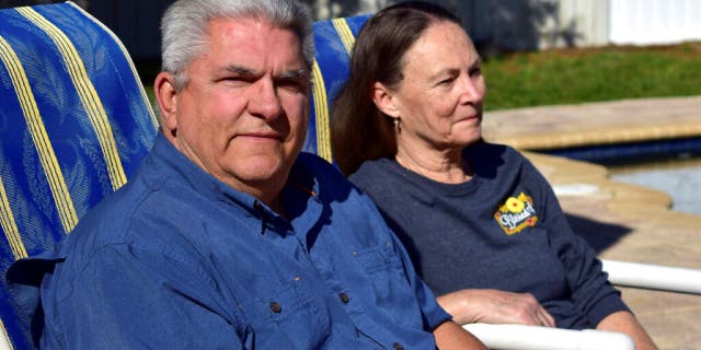 Louis Minardi and Raye Ellen Minardi sit by their pool on Gunn Highway in Odessa, Fla., on Jan. 29, 2023. The swimming pool in the backyard of Louis Minardi’s home may be distinctive to Florida: The custom-built pool is shaped like a six-shooter revolver, in a state made famous – sometimes infamous – by guns, gun politics and gun culture.