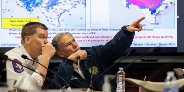 (L-R) Chief of the Texas Division of Emergency Management Nim Kidd and Texas Gov. Greg Abbott observe weather patterns during a briefing on January 31, 2023, in Austin, Texas. Gov. Abbott held a meeting and news conference in preparation for the winter storm that is sweeping across portions of Texas.