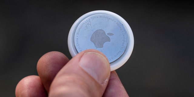 Someone holds an Apple AirTag in San Francisco, March 14, 2022. 