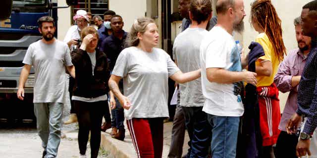 Seven of the Croatians charged with attempting to traffic children stand outside the magistrates court in Ndola, Zambia, on Jan. 10, 2023. All eight of the Croatians pleaded not guilty to the charge of child trafficking before a magistrate.