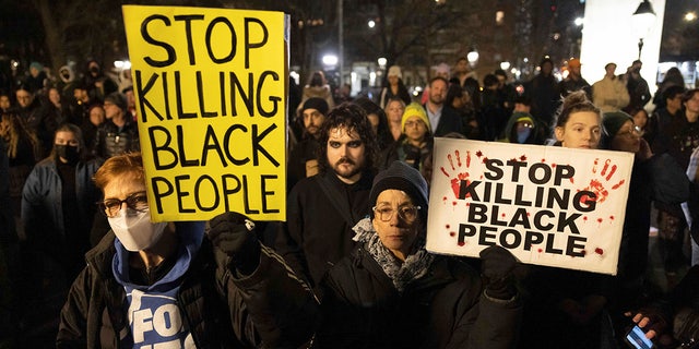 Demonstrators hold signs during a protest at Washington Square Park in New York City on Jan. 28, 2023, in response to the death of Tyre Nichols.