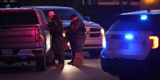 Las Vegas police work near the home of former actor Nathan Lee Chasing Horse as he walks past him in North Las Vegas, Nevada, Tuesday, January 31, 2023.