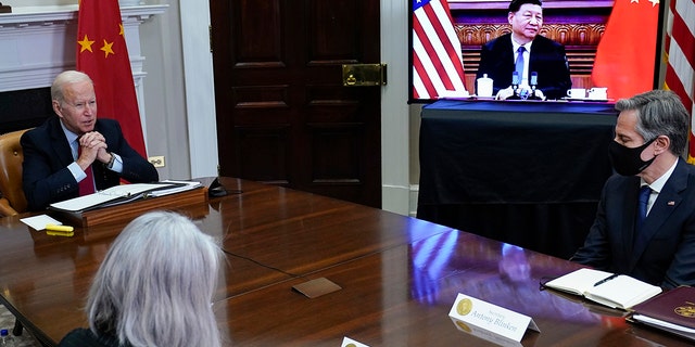 President Joe Biden virtually meets Chinese President Xi Jinping from the Roosevelt Room at the White House as Secretary of State Anthony Blinken (right) listens. 