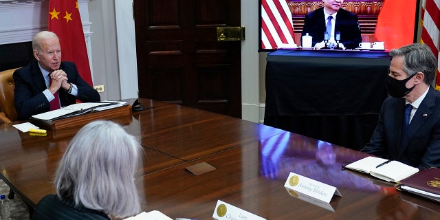 President Joe Biden meets virtually with Chinese President Xi Jinping from the Roosevelt Room of the White House, as Secretary of State Antony Blinken, right, listens. 