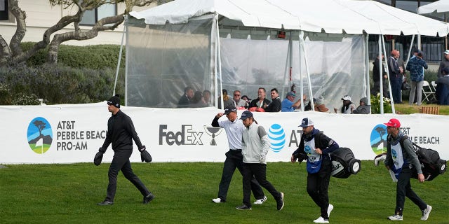From left, the playing group of Beau Hossler, Max McGreevy and Lukas Nelson walk toward the 14th fairway of the Pebble Beach Golf Links during the second round of the ATT Pebble Beach Pro-Am golf tournament in Pebble Beach, Calif., Friday, Feb. 3, 2023. A caddie for one of the amateurs in the group collapsed on the 11th fairway and was rushed to the hospital.