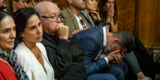 Lucas Delfino, leaning over at right, sits with other members of telenovela star Pablo Lyle's family as he begins to cry as Lyle's sentence is read by Judge Marisa Tinkler Mendez in Miami-Dade Criminal Court in Miami, Friday, Feb. 3, 2023.