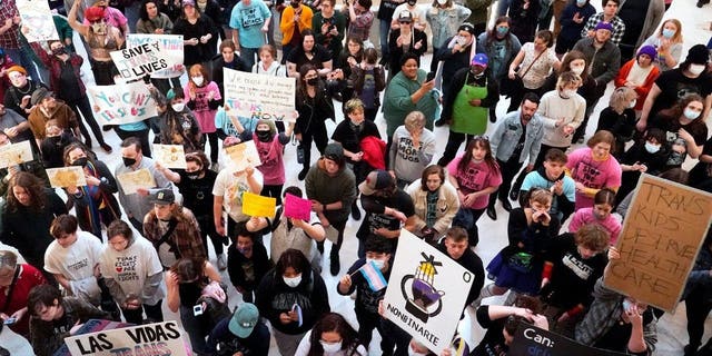 Trans-rights activists protest outside the House chamber at the state Capitol before the State of the State address Monday, Feb. 6, 2023, in Oklahoma City. 