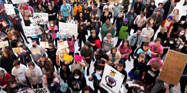 Trans-rights activists protest outside the House chamber at the state Capitol before the State of the State address Monday, Feb. 6, 2023, in Oklahoma City.