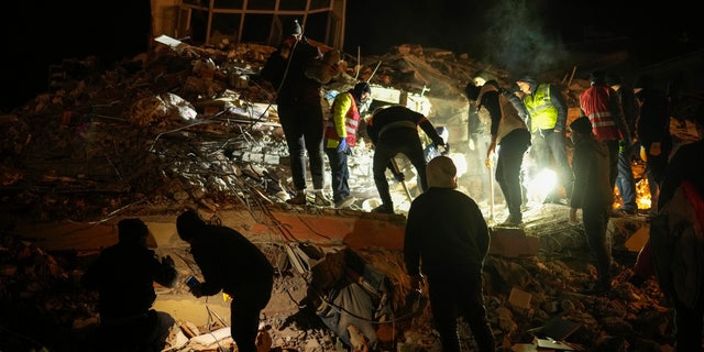 People and rescue teams search for survivors in destroyed buildings in Elbistan, southern Turkey, Wednesday, Feb. 8, 2023.