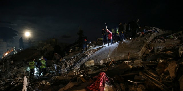 Rescue teams search for people at a destroyed building, in Adiyaman, southeastern Turkey, Wednesday, Feb. 8, 2023.