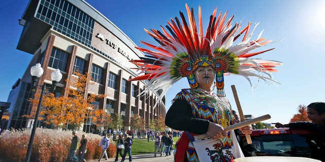 A woman plays a drum during a "No Honor in Racism Rally" in front of TCF Bank Stadium before an NFL football game between the Minnesota Vikings and the Kansas City Chiefs, on Oct. 18, 2015, in Minneapolis.