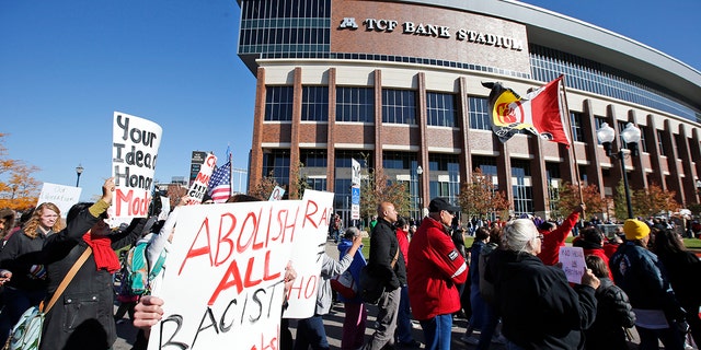 A "No Honor in Racism Rally" marches in front of TCF Bank Stadium before an NFL football game between the Minnesota Vikings and the Kansas City Chiefs, on Oct. 18, 2015, in Minneapolis. 
