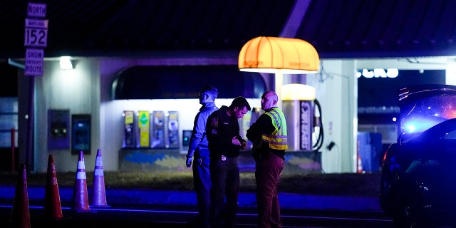 Police officers stand at a checkpoint on Mountain Road and Belair Road where a suspected gunman is believed to be at-large, Thursday, Feb. 9, 2023, in Fallston, Md.