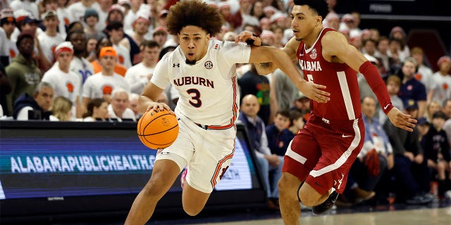 Auburn guard Tre Donaldson dribbles around Alabama guard Jahvon Quinerly, Saturday, Feb. 11, 2023, in Auburn, Alabama.