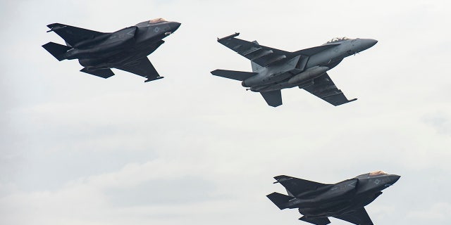 Aircraft from the aircraft carrier USS Nimitz and the USS Makin Island fly in formation past Nimitz in the South China Sea, on Feb. 12, 2023.