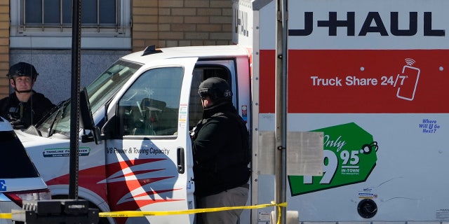 Members of the NYPD bomb squad examine a rental truck that plowed into nine people on Feb. 13, 2023, in the Bay Ridge area of Brooklyn. 