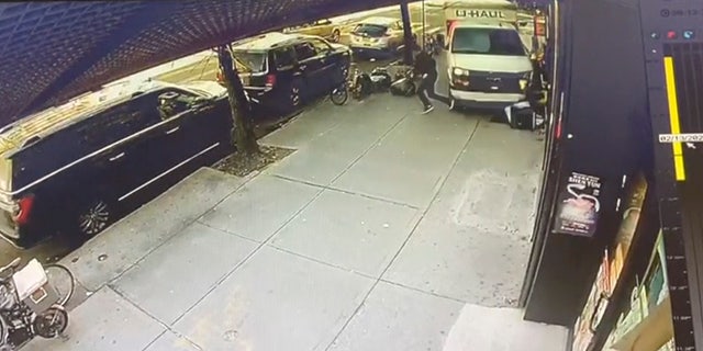 In this photo taken from security video, a man jumps out of the way as a U-Haul truck drives onto the sidewalk on Feb. 13, 2023, in Bay Ridge, Brooklyn.