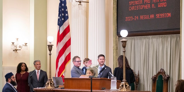 Anggota majelis Chris Ward, didampingi oleh pasangannya Thom Harpole, dan anak-anak Betty dan Billy saat dia dilantik sebagai Pembicara Pro Tempore selama sesi pembukaan Badan Legislatif California di Sacramento, California, pada 5 Desember 2022.