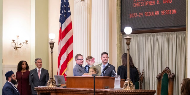 Anggota majelis Chris Ward, didampingi oleh pasangannya Thom Harpole, dan anak-anak Betty dan Billy saat dia dilantik sebagai Pembicara Pro Tempore selama sesi pembukaan Badan Legislatif California di Sacramento, California, pada 5 Desember 2022.