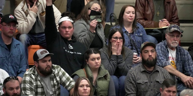 A woman raises her hand with a question during a town hall meeting at East Palestine High School in East Palestine, Ohio, Wednesday, Feb. 15, 2023. The meeting was held to answer questions about the ongoing cleanup from the derailment on Feb, 3, of a Norfolk Southern freight train carrying hazardous material.
