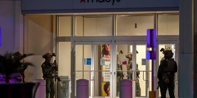 Police officers stand guard at an entrance of a shopping mall, Wednesday, Feb. 15, 2023, in El Paso, Texas. 