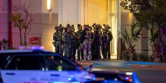 Police officers gather at an entrance of a shopping mall, Wednesday, Feb. 15, 2023, in El Paso, Texas.  